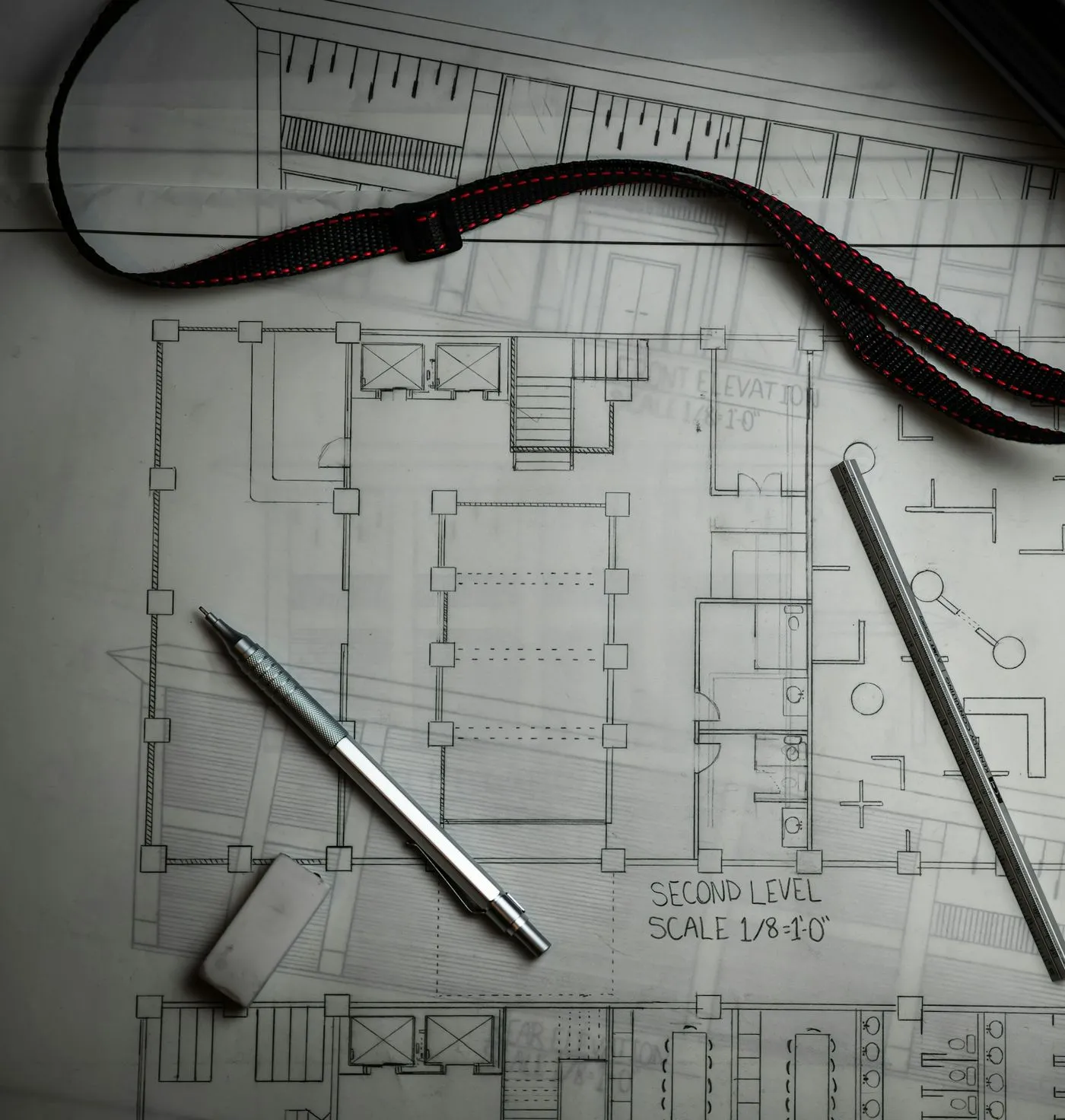 Floor plan drawing with a mechanical pencil, a steel ruler and an eraser on top