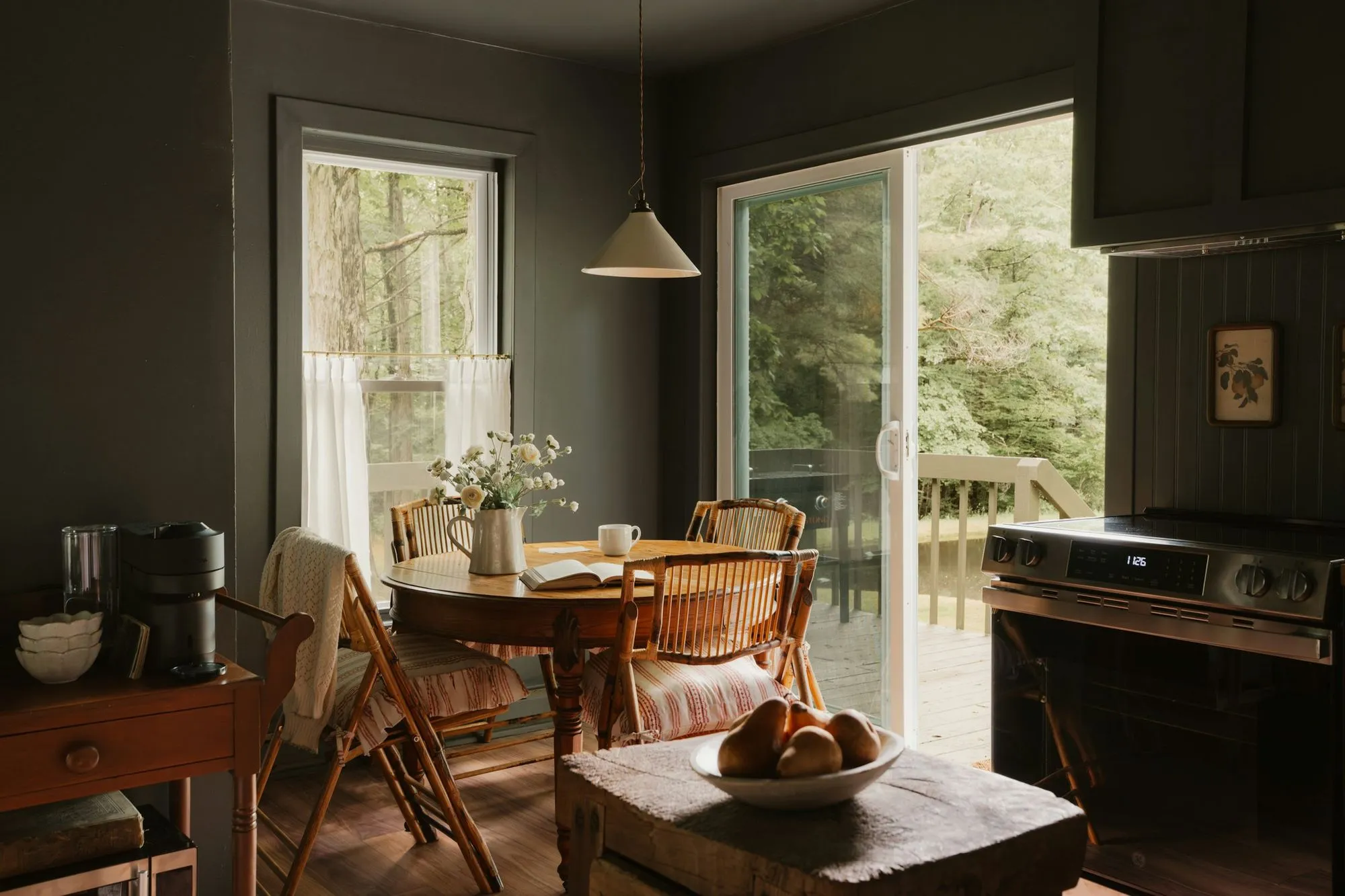 Breakfast room with dark green walls, a round wood table and a sliding door to the yard